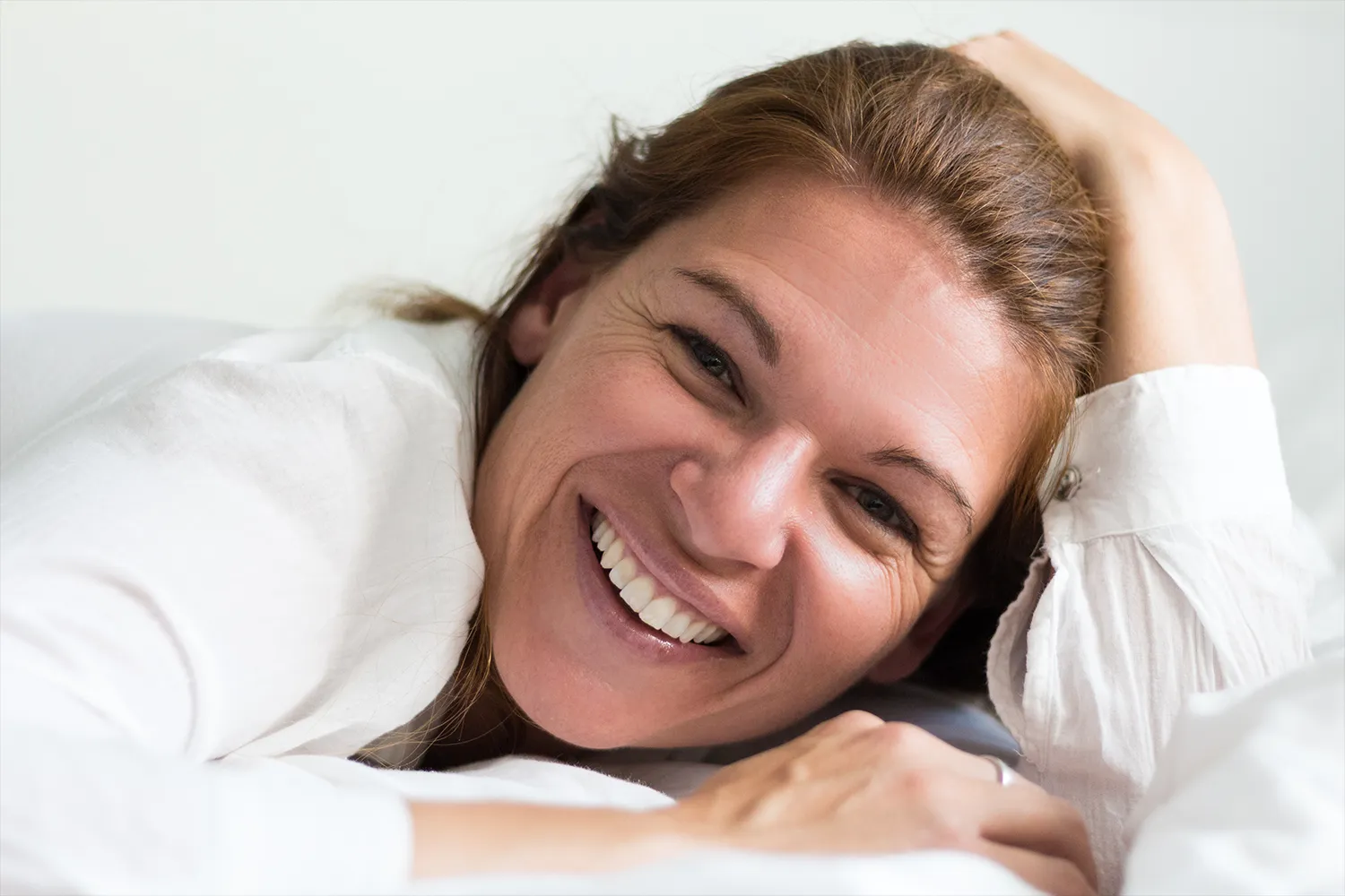 A closeup of a woman is smiling towards the camera